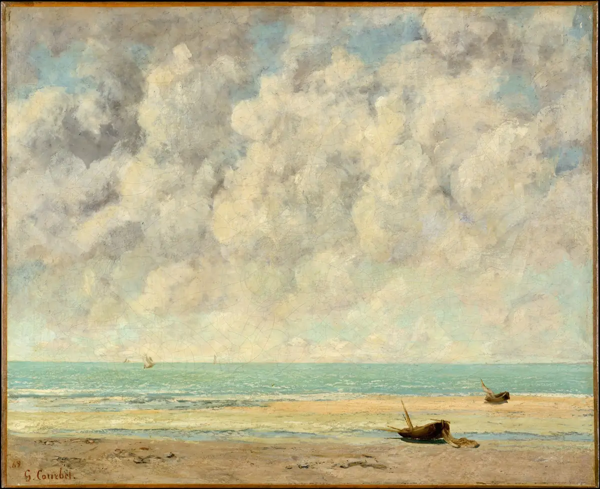 Pintura de Gustave Courbet: uma praia de areia com dois pequenos barcos pousados, um mar verde-azulado e sereno com velas ao longe, sob um céu amplo cheio de nuvens claras